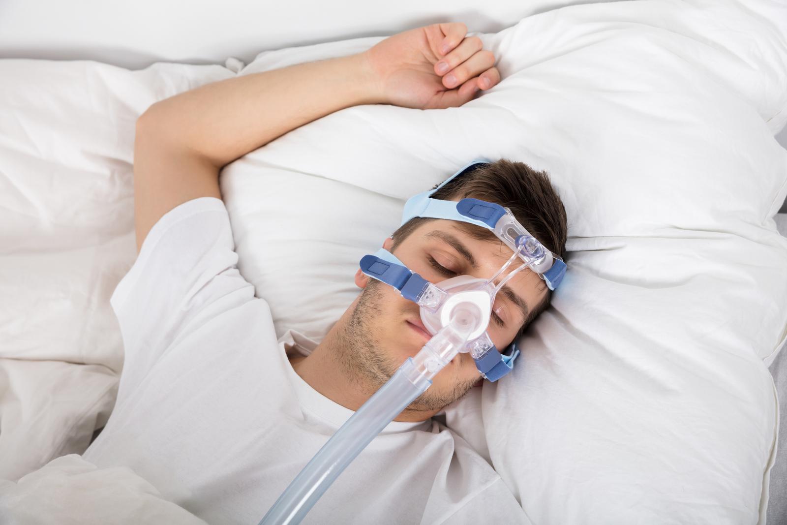 Man lying in bed with his CPAP machine